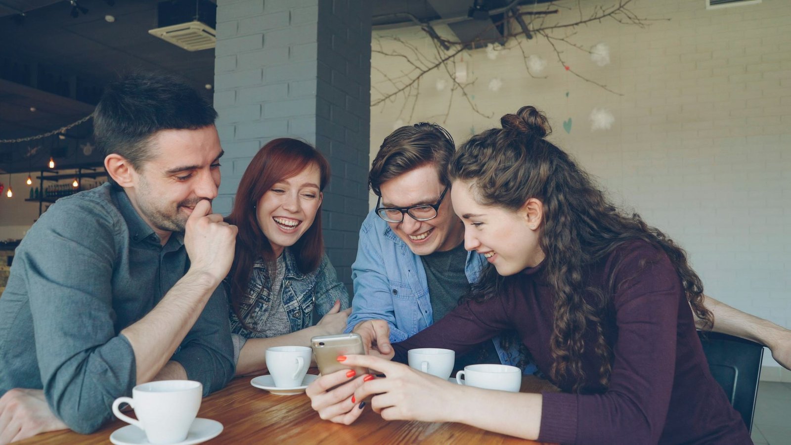 Un gruppo di amici ride guardando uno smartphone