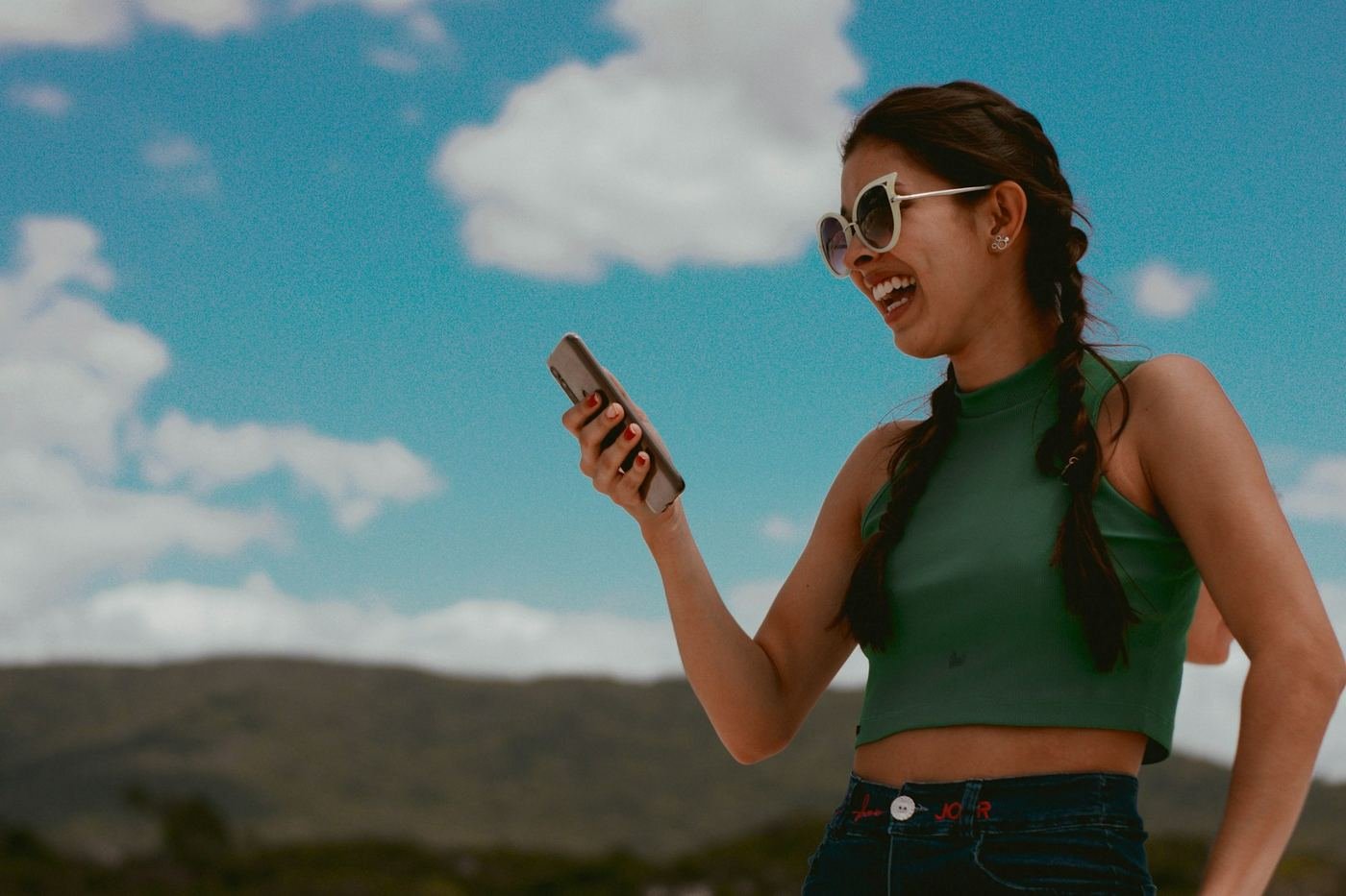 Una ragazza all'aperto sorride al telefono