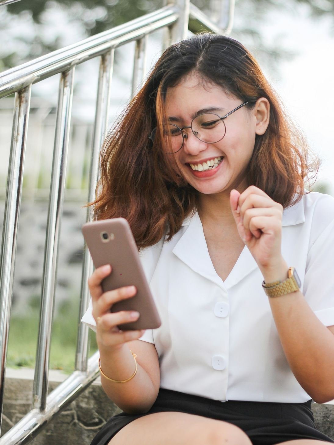 Una ragazza ride guardando lo smartphone